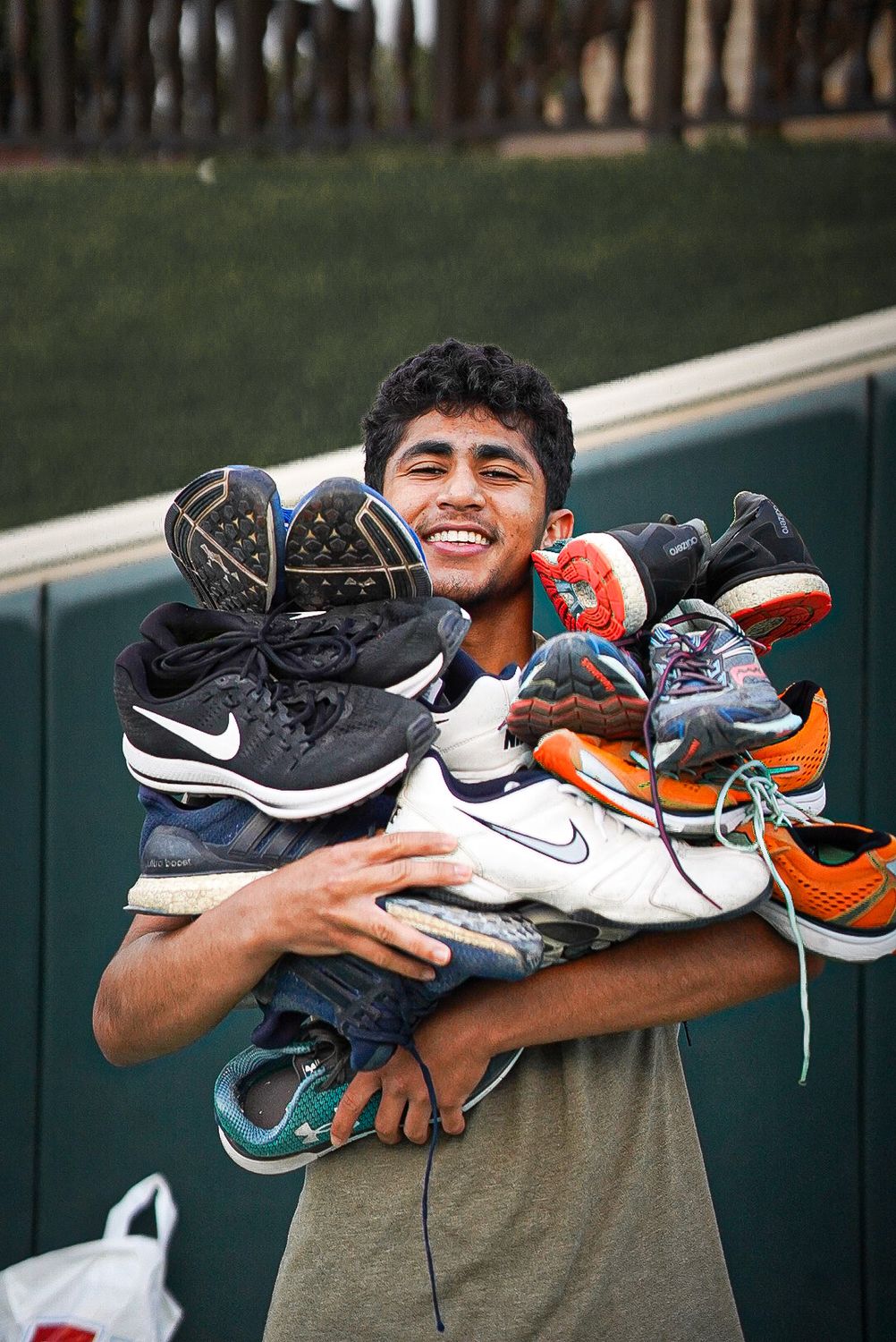 Zach holding an armful of donated running shoes