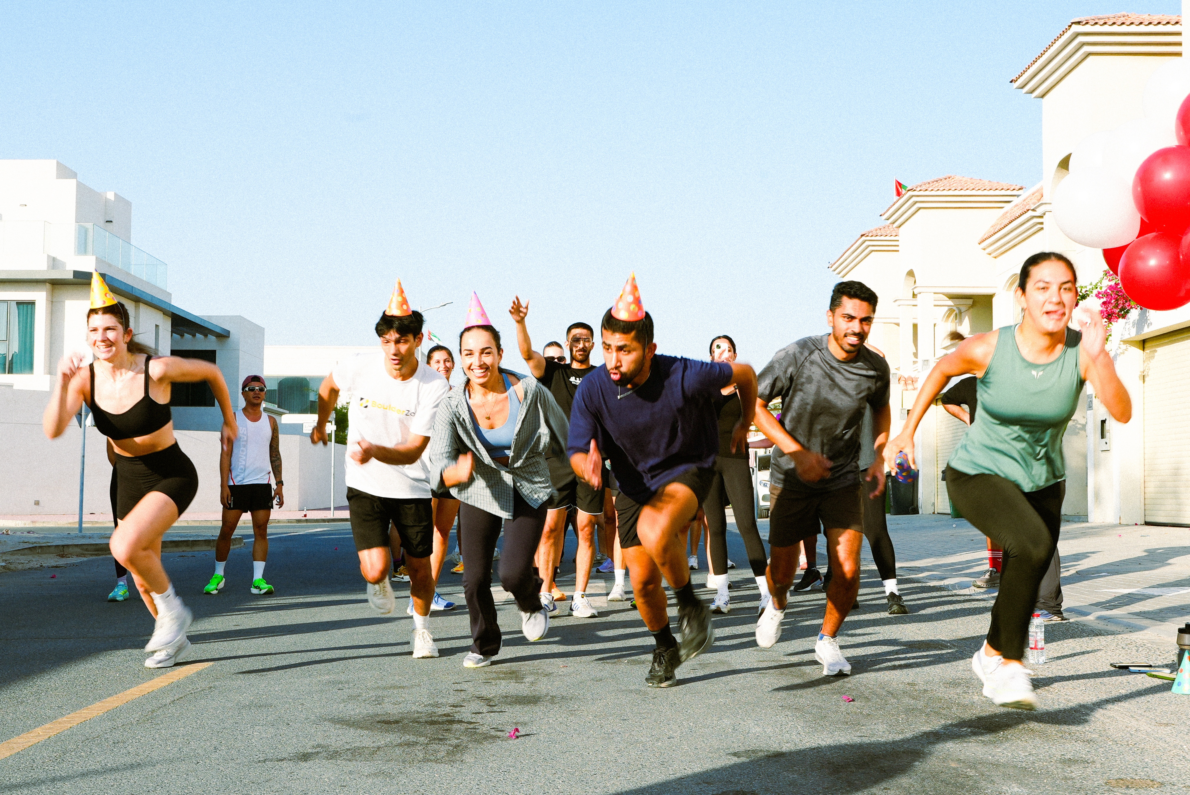 RunKwa runners in party hats sprinting down a Dubai street