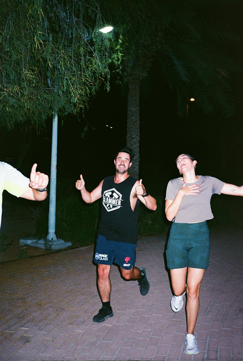 Runners laughing and giving thumbs up on a night run