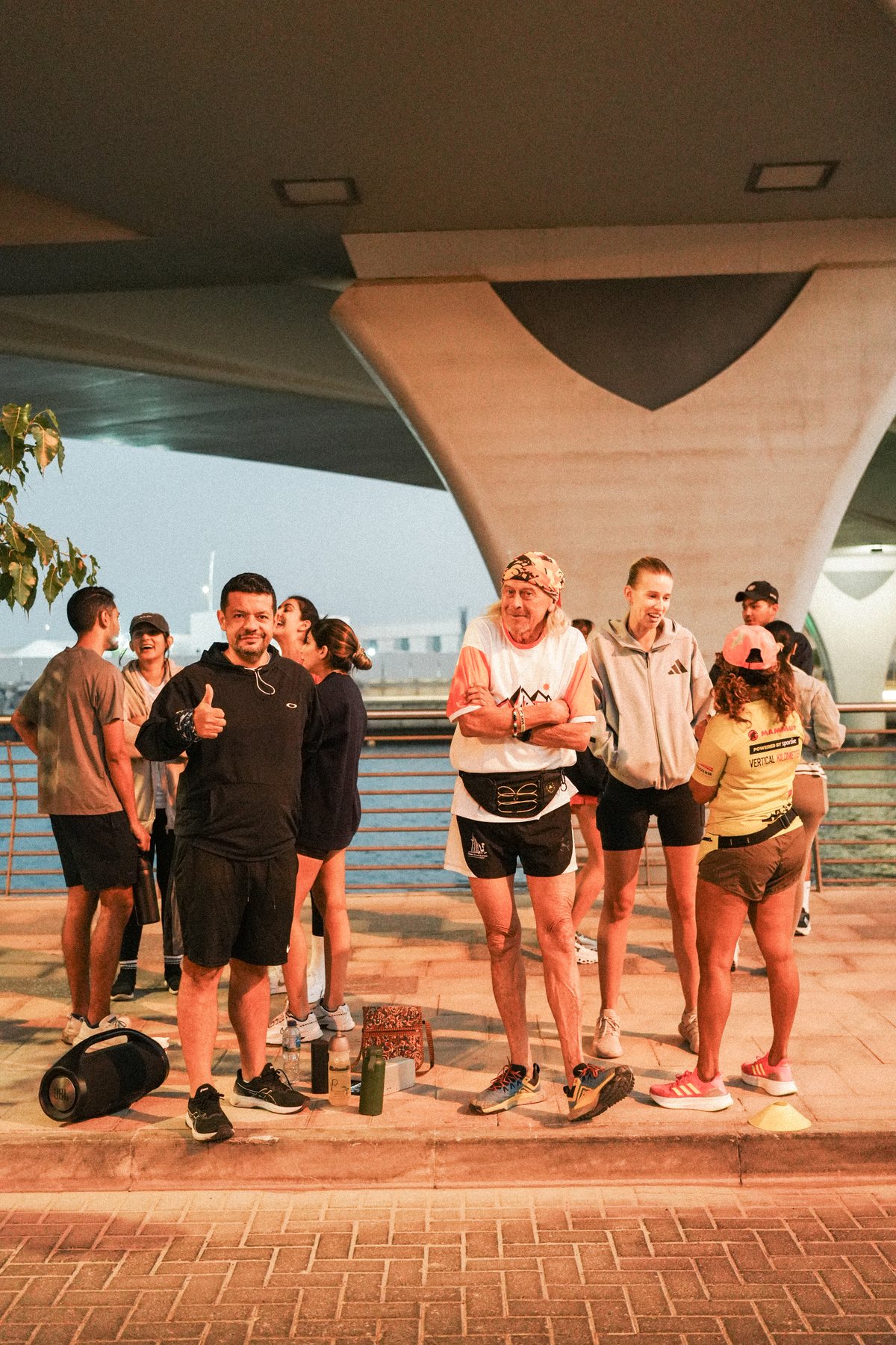 TheRunClub runners gathered under the bridge before the Orto run, one giving a thumbs up